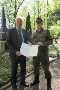 Das Foto zeigt Bürgermeister Walter Kiß und OFw d.R. Rainer Koch bei der Übergabe der Patenschaftsurkunde auf dem Friedhof in Eichen.