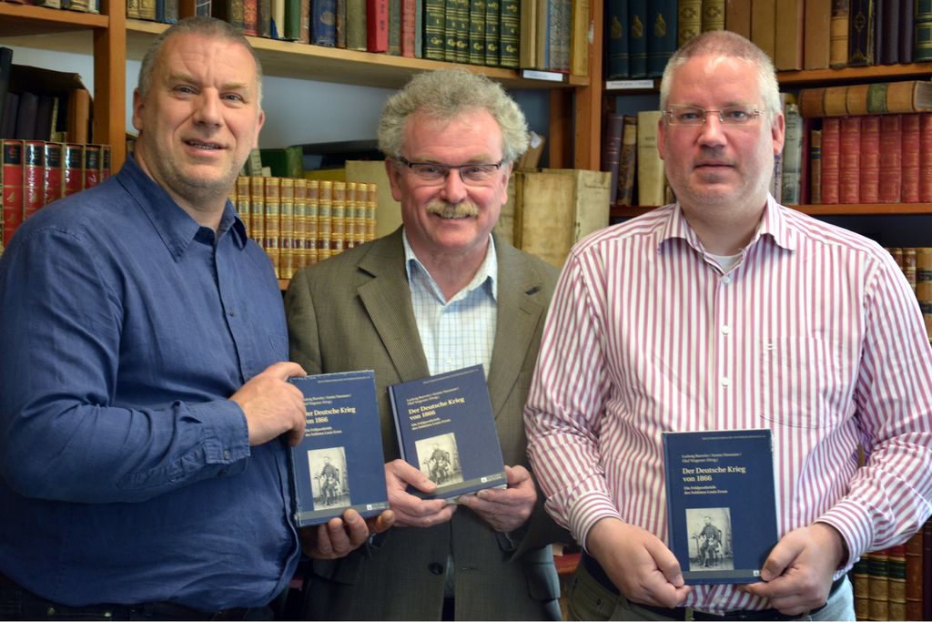 Buchvorstellung durch Armin Nassauer, den Siegener Stadtarchivar Ludwig Burwitz und den Historiker Olaf Wagener (von links nach rechts) in den Räumen des Antiquariates. 